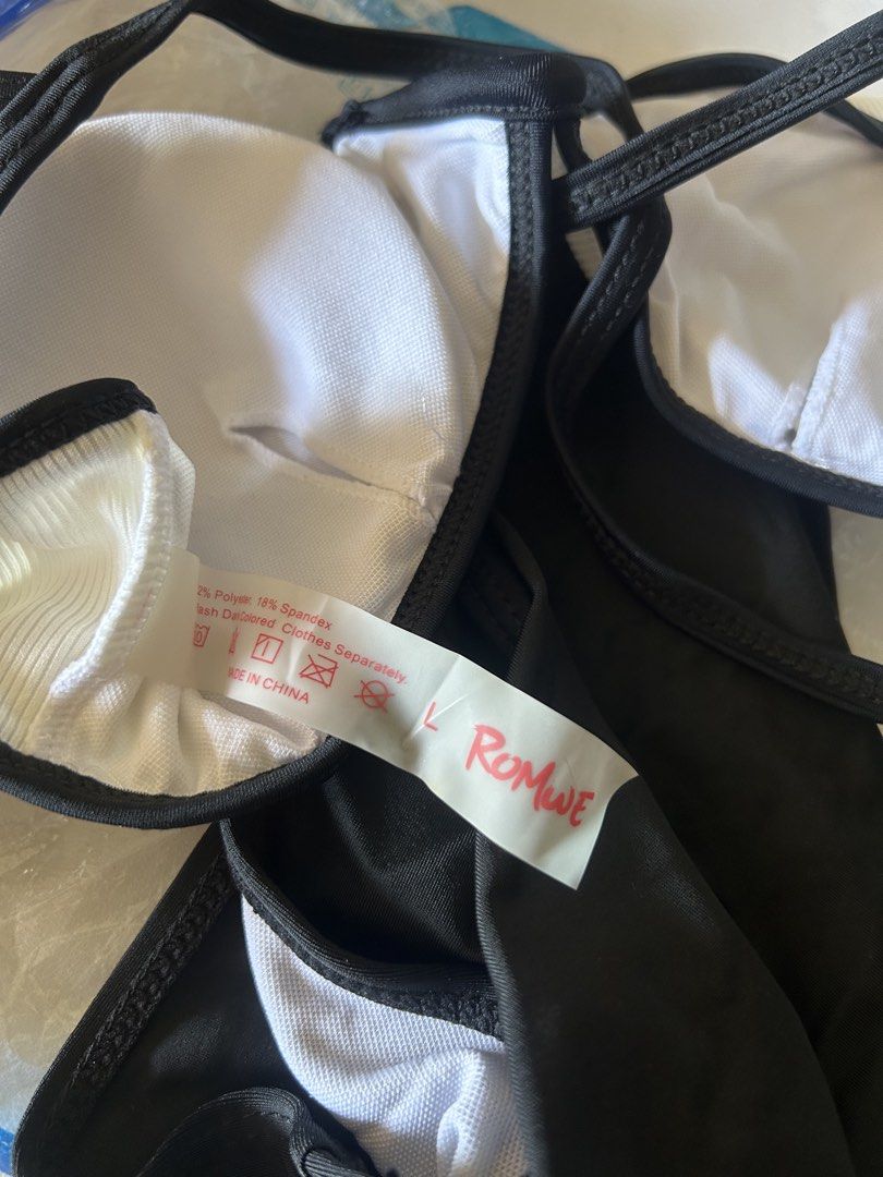 Romwe Black and White Two-Piece Bikini Size L (Category: Bikinis & Swimsuits) located in Bulacan. Submitted by peach1025 (Listing ID 1468065027, Image 3). Description: - Brand: Romwe - Type: Two-piece bikini set - Size: L (tag attached) - Top: White ribbed with black trim and crossover back straps - Bottoms: High-waisted black - Material: 82% polyester, 18% spandex - Care: Hand wash separately - Origin: Made in China.