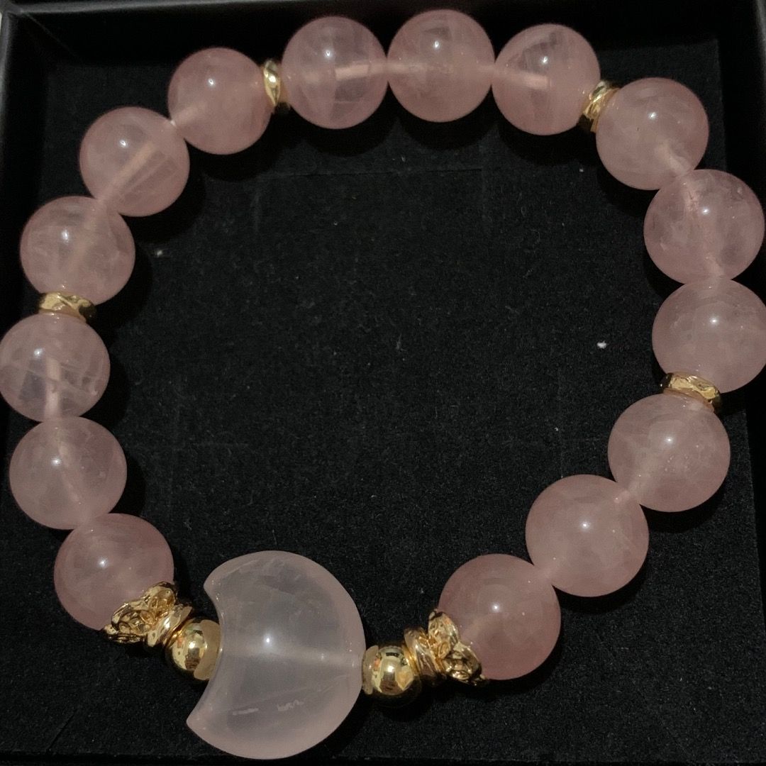 Rose Quartz Crystal Moon Charm Beaded Bracelet (Category: Bracelets) located in Quezon City. Submitted by itscxyy (Listing ID 1468066262, Image 2). Description: - Material: Genuine natural rose quartz gemstone beads from Madagascar with gold-toned metal spacers - Focal Piece: Beautiful large carved crescent moon bead in the center - Fit: Comfortable elastic cord for quick slip-on and slip-off wear - Appearance: Pale pink stones with a lovely ligh