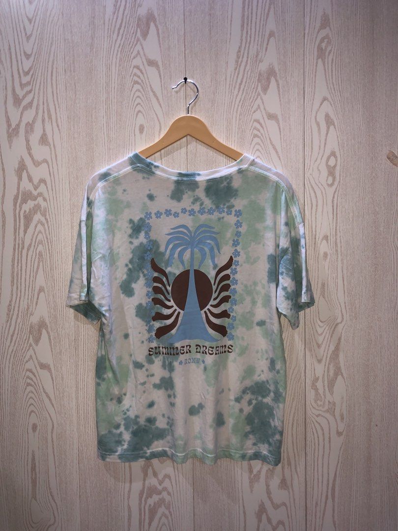 ROXY Summer Dreams Tie Dye T-Shirt (Category: Shirts) located in Magsaysay. Submitted by ryns_thrifting (Listing ID 1468165137, Image 3). Description: - Brand: ROXY - Design: Green and white tie-dye with small chest logo - Back Graphic: Large palm tree with 'SUMMER DREAMS' text - Fit: Relaxed fit with short sleeves and crew neck - Condition: Great piece for casual wear.