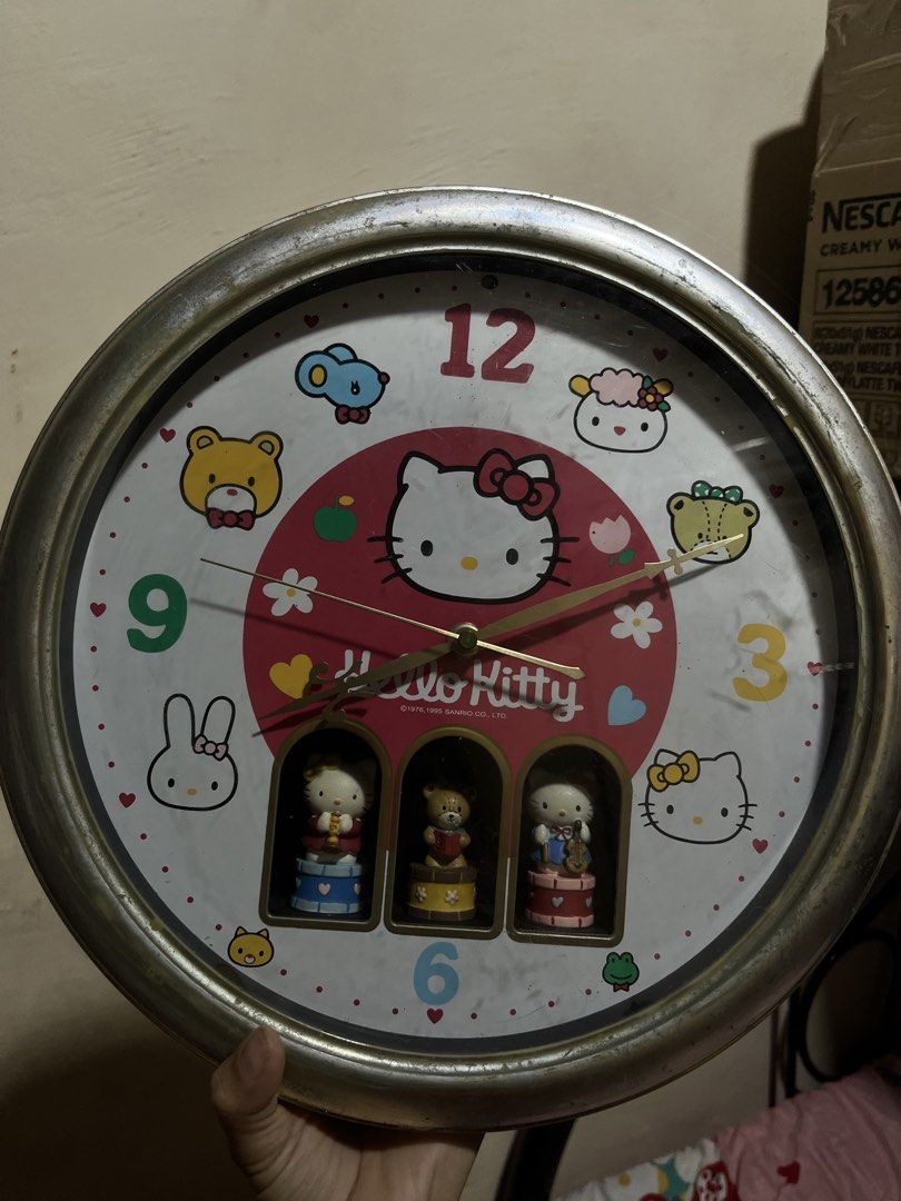 Sanrio Hello Kitty Vintage Wall Clock with Rotating Figures (Category: Clocks) located in Manila. Submitted by janetecson05 (Listing ID 1468214612, Image 1). Description: - Vintage Sanrio wall clock featuring Kitty and Little Twin Stars - Large round face with classic number markers at 12, 3, 6, and 9 - Features 3 small rotating compartments at the bottom with instrument-playing figures - Stylish silver-toned frame - Battery-operated (requires ba