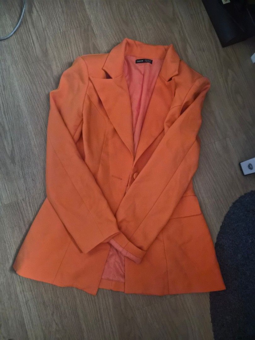 SHEIN Prive Orange Tailored Blazer Size M (Category: Coats, Jackets and Outerwear) located in Cavite. Submitted by frombellas (Listing ID 1468091917, Image 2). Description: - Brand: SHEIN - Size: Medium (EU 38, US 6) - Color: Bright orange with matching reddish-orange lining - Design: Single button closure, structured lapels, and cinched waist - Condition: Clean, excellent with no damage - Versatile piece great for office wear or night outs.