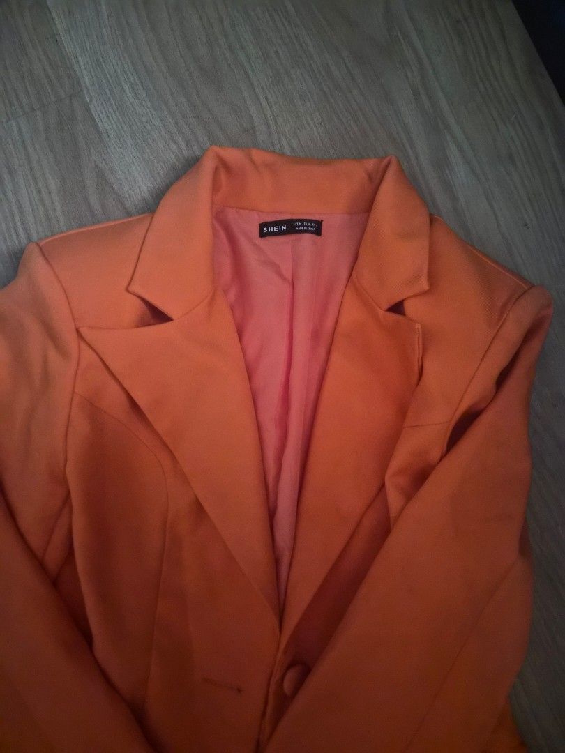 SHEIN Prive Orange Tailored Blazer Size M (Category: Coats, Jackets and Outerwear) located in Cavite. Submitted by frombellas (Listing ID 1468091917, Image 3). Description: - Brand: SHEIN - Size: Medium (EU 38, US 6) - Color: Bright orange with matching reddish-orange lining - Design: Single button closure, structured lapels, and cinched waist - Condition: Clean, excellent with no damage - Versatile piece great for office wear or night outs.