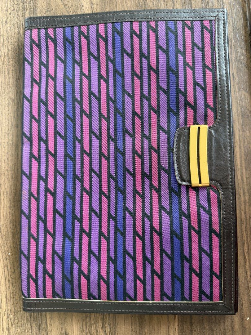 Shiseido Patterned Clutch Bag with Brown Leather Trim (Category: Clutches) located in Digos. Submitted by old_soul. (Listing ID 1468100217, Image 1). Description: - Brand: Shiseido - Type: Clutch Bag - Exterior: Vibrant purple and pink geometric fabric pattern with brown leather trim - Hardware: Elegant gold-tone clasp closure - Interior: Brown fabric lining with a convenient zippered pocket - Closure: Secure magnetic snap closure - Details: Stam