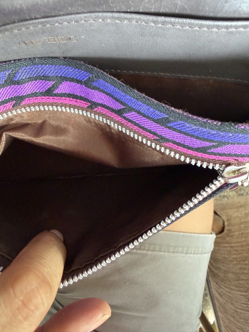 Shiseido Patterned Clutch Bag with Brown Leather Trim (Category: Clutches) located in Digos. Submitted by old_soul. (Listing ID 1468100217, Image 3). Description: - Brand: Shiseido - Type: Clutch Bag - Exterior: Vibrant purple and pink geometric fabric pattern with brown leather trim - Hardware: Elegant gold-tone clasp closure - Interior: Brown fabric lining with a convenient zippered pocket - Closure: Secure magnetic snap closure - Details: Stam