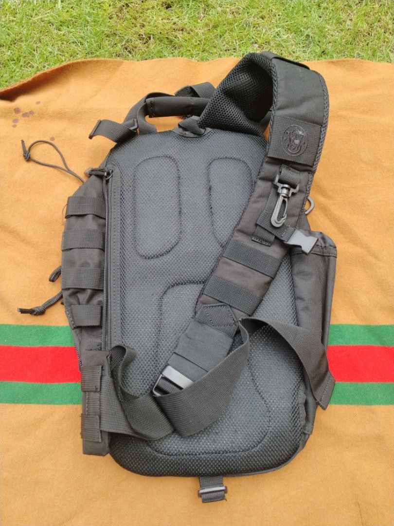 Smith & Wesson tactical sling backpack black (Category: Sling Bags) located in Legazpi City. Submitted by genobecollectives (Listing ID 1468080919, Image 2). Description: Smith & Wesson tactical sling backpack in all black. Durable nylon material with heavy-duty zippers and paracord pulls. Multiple exterior zippered compartments, MOLLE webbing straps, and bungee cords on the front pocket. Padded mesh back panel and single adjustable shoulder stra