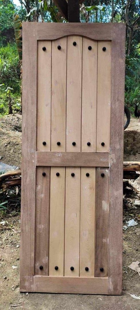 Solid Wooden Door Handcrafted Paneled Design (Category: Locks, Doors & Gates) located in Quezon City. Submitted by anglerose070187 (Listing ID 1468088789, Image 1). Description: - Handcrafted solid wood door with a heavy, durable build - Features traditional vertical panels and decorative round studs - Comes in a natural wood finish, ready for your choice of paint or stain - Sourced directly from a trusted local carpentry shop - Perfect for addin