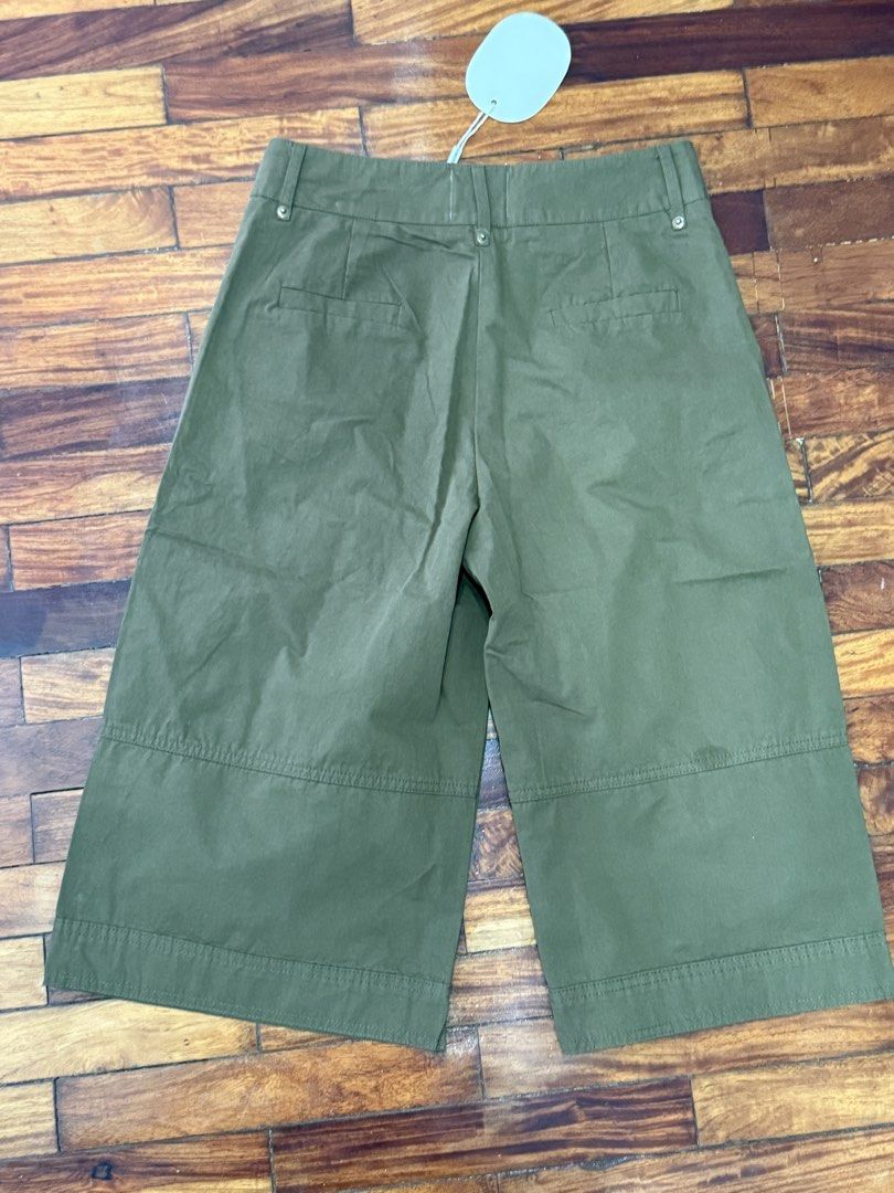 Something Else Olive Green Wide Leg Culotte Shorts (Category: Shorts) located in Pasig City. Submitted by atbp__ (Listing ID 1468093622, Image 3). Description: - Brand: Something Else - Condition: Brand new with tags (Unworn) - Color: Olive green - Style: High waist culotte shorts with double gold-tone buttons and front pleats - Details: Horizontal panelling near the hem - Pockets: Functional side pockets and back welt pockets.