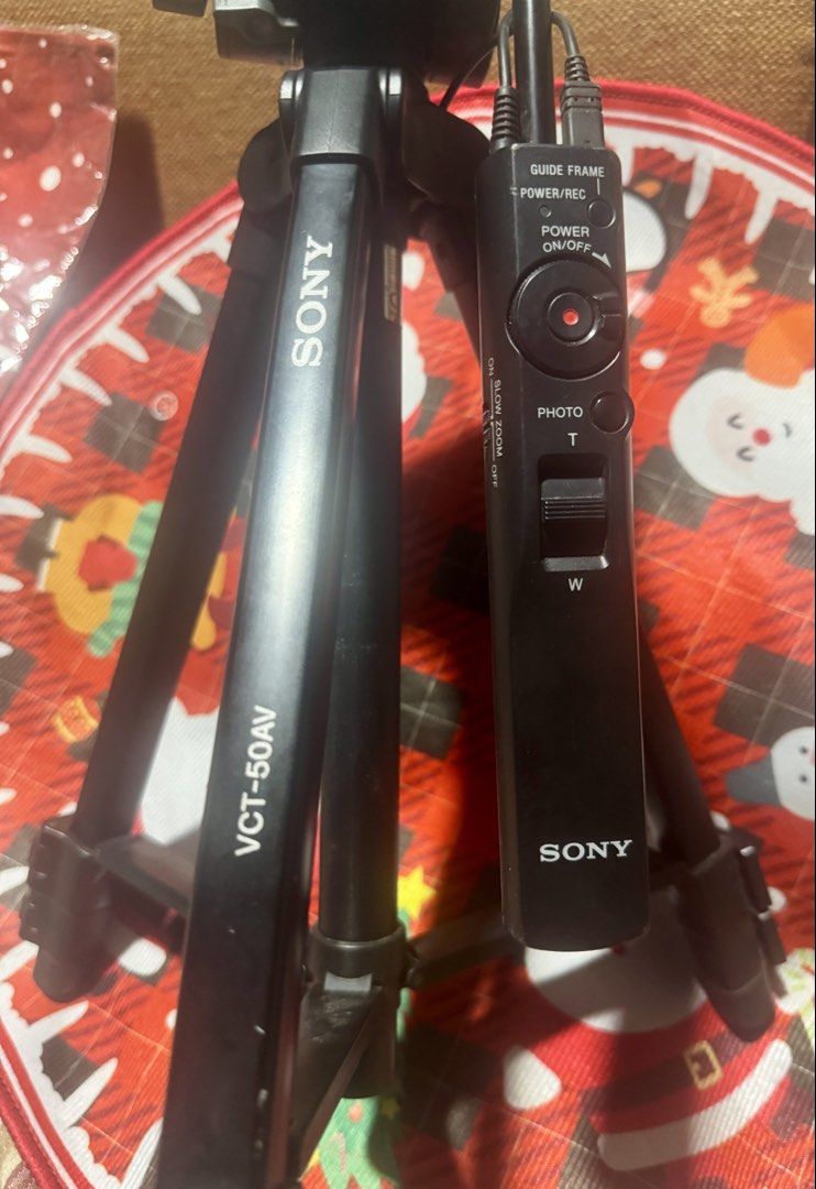 Sony VCT-50AV Remote Control Tripod (Category: Tripods & Monopods) located in Quezon City. Submitted by angace13 (Listing ID 1468236333, Image 2). Description: Sony VCT-50AV tripod for handycam and cameras. Built-in remote control handle with power, record, photo, and slow zoom functions. Multi-use remote cable attached. Solid black build, sturdy legs with adjustable height. Great for steady video recording and stable shots. Fully working remote 