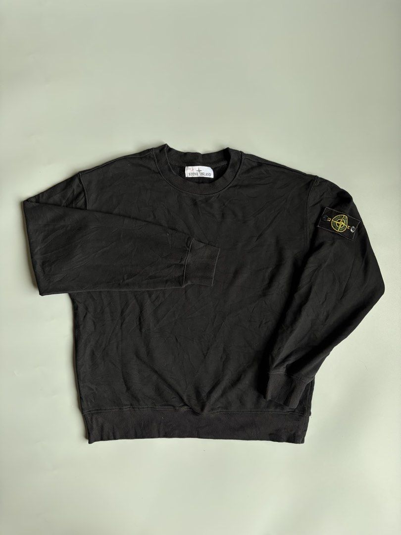 Stone Island Black Sweatshirt (Category: Coats, Jackets and Outerwear) located in Kibawe. Submitted by jeloots (Listing ID 1468085556, Image 1). Description: - Brand: Stone Island - Color: Black - Size: M - Material: 98% cotton, 2% elastane - Design: Classic crewneck with ribbed cuffs and hem - Detail: Signature compass badge buttoned on the left sleeve - Authenticity: Certilogo tag attached inside - Condition: Clean, pre-owned piece.