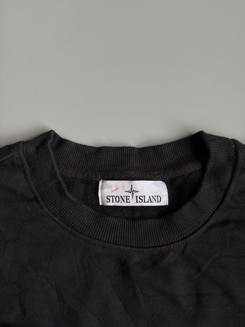 Stone Island Black Sweatshirt (Category: Coats, Jackets and Outerwear) located in Kibawe. Submitted by jeloots (Listing ID 1468085556, Image 2). Description: - Brand: Stone Island - Color: Black - Size: M - Material: 98% cotton, 2% elastane - Design: Classic crewneck with ribbed cuffs and hem - Detail: Signature compass badge buttoned on the left sleeve - Authenticity: Certilogo tag attached inside - Condition: Clean, pre-owned piece.
