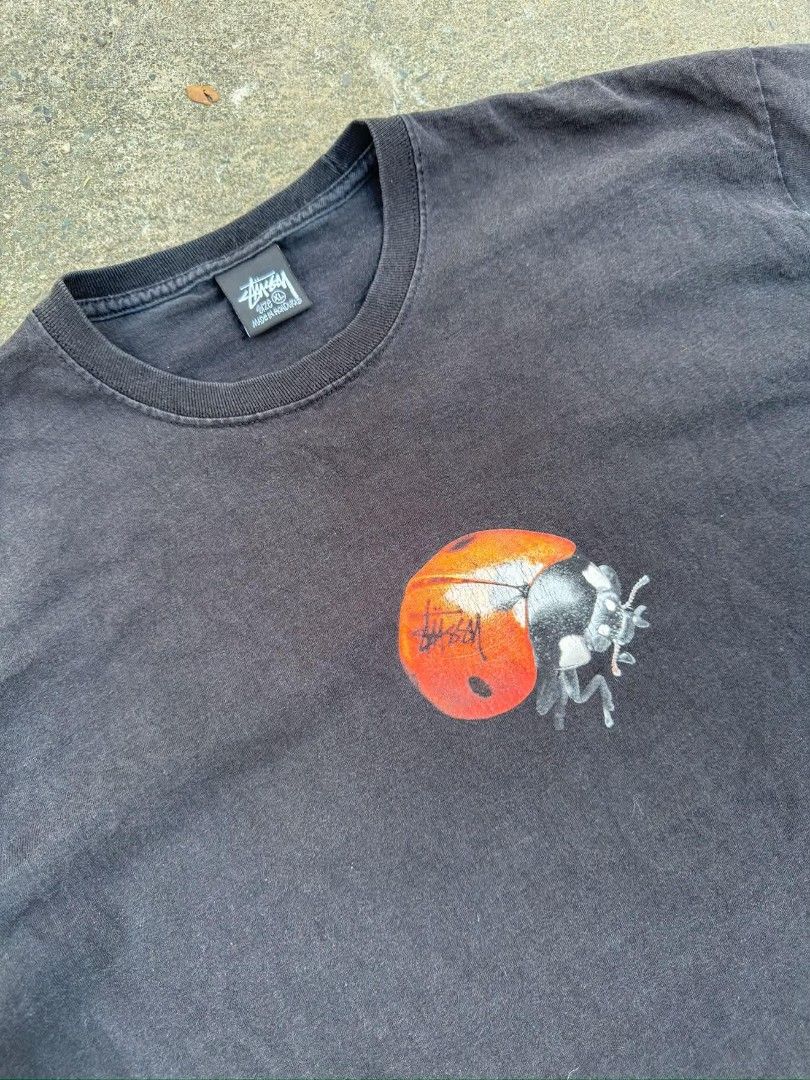 Stussy Ladybug Graphic Tee Black Size XL (Category: Tshirts & Polo Shirts ) located in Manila. Submitted by silentstone.4b0628 (Listing ID 1468059741, Image 1). Description: - Brand: Stussy - Color: Washed black (soft faded texture) - Size: XL (tagged, made in Honduras) - Design: Detailed ladybug graphic with embedded Stussy logo on the front chest - Fit: Classic crew neckline and short sleeves - Condition: Pre-loved with a great vintage look.