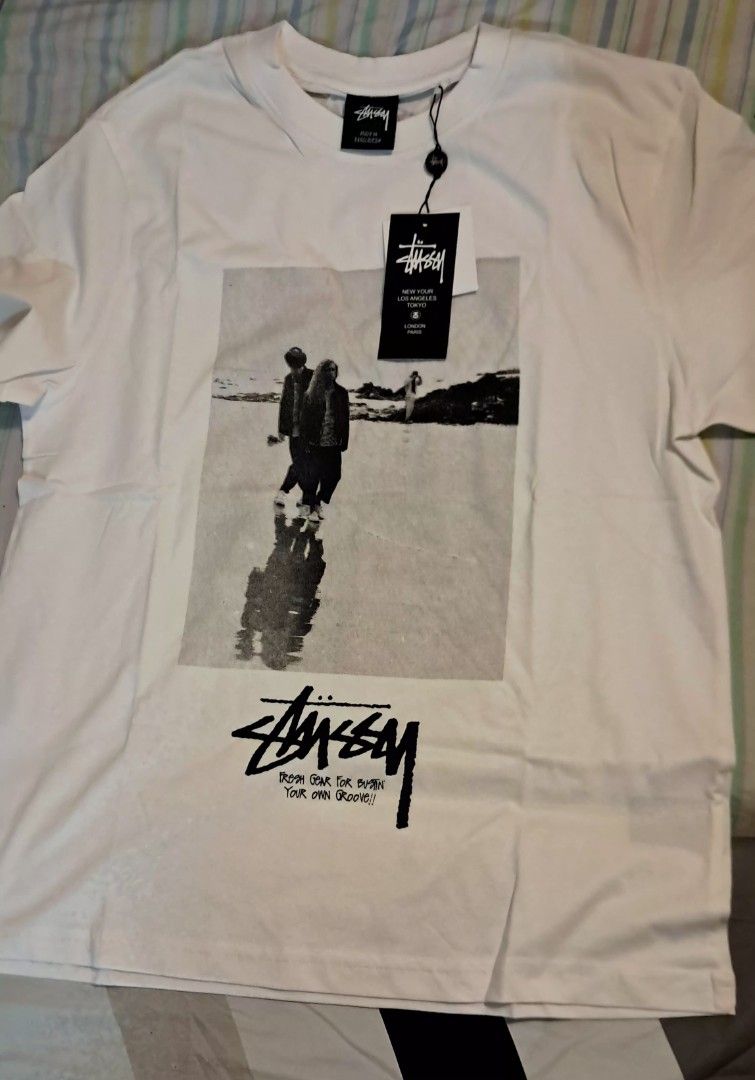 Stussy White T-Shirt (Category: Luxury Apparel) located in Muntinlupa City. Submitted by ch3ll3li (Listing ID 1468176071, Image 1). Description: Writing FOR SALE: White Stüssy-Style Graphic T-Shirt 🤍🖤 ✨ Minimalist Streetwear | Black & White Graphic Print Selling this white graphic T-shirt featuring a vintage-style beach photo and bold black lettering. Perfect for streetwear outfits, casual wear, and everyday styling. Details: Color: White Desig