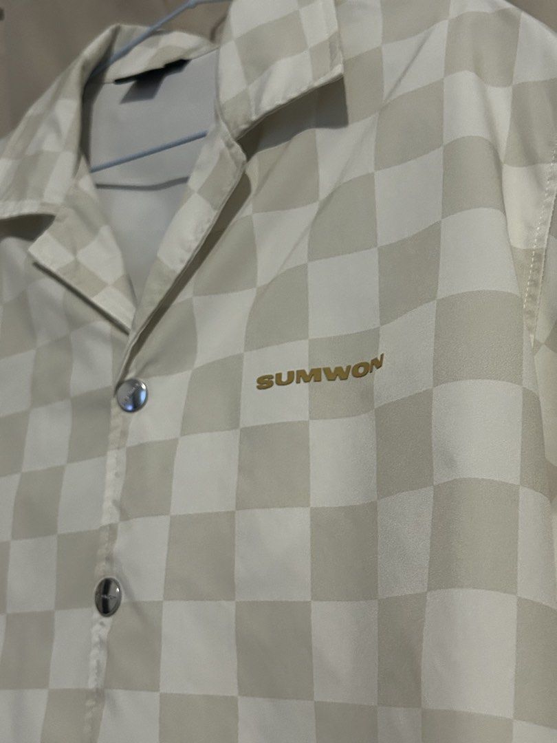 SUMWON Checkered Short Sleeve Shirt (Category: Tshirts & Polo Shirts ) located in Dasmarinas. Submitted by brandedstuff.est2022 (Listing ID 1468165840, Image 2). Description: - Brand: SUMWON - Design: Cream and beige checkered pattern - Style: Camp collar, short sleeves, relaxed boxy fit - Details: Engraved branded metal snap buttons, embroidered 'SUMWON' logo on left chest - Size: Small.