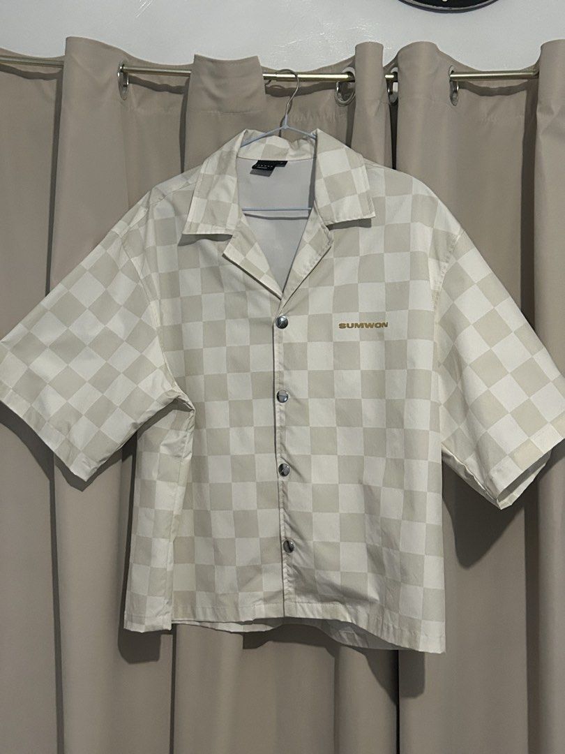 SUMWON Checkered Short Sleeve Shirt (Category: Tshirts & Polo Shirts ) located in Dasmarinas. Submitted by brandedstuff.est2022 (Listing ID 1468165840, Image 1). Description: - Brand: SUMWON - Design: Cream and beige checkered pattern - Style: Camp collar, short sleeves, relaxed boxy fit - Details: Engraved branded metal snap buttons, embroidered 'SUMWON' logo on left chest - Size: Small.