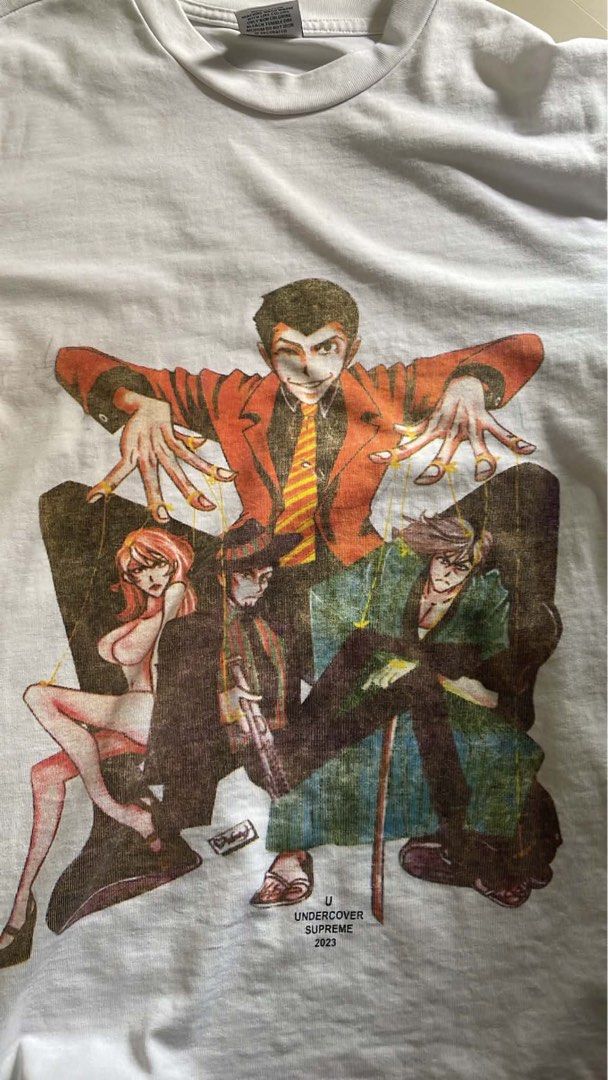 Supreme Undercover Lupin The Third Tee White Small (Category: Tshirts & Polo Shirts ) located in Calauan. Submitted by thrift_joms (Listing ID 1468197315, Image 1). Description: - Brand: Supreme x Undercover - Year: 2023 - Color: White - Size: Small - Design: Lupin III graphic print with puppet strings on the front - Material: 100% cotton with original neck and interior wash tags.