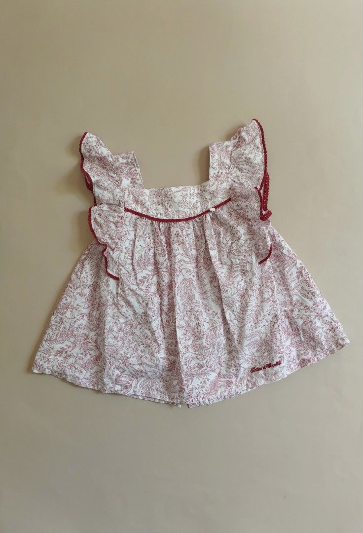 Tartine et Chocolat Blouse 3yo (Category: Babies & Kids Fashion) located in Cebu City. Submitted by little_mush.room (Listing ID 1468153516, Image 1). Description: - Brand: Tartine et Chocolat - Size: 100 /3yo - Color/Design: White with red botanical leaf print - Details: Ruffled shoulders with red scalloped trim, embroidered logo near the hem - Closure: Back button closure with branded mother-of-pearl buttons - Material: Soft, premium cotton .