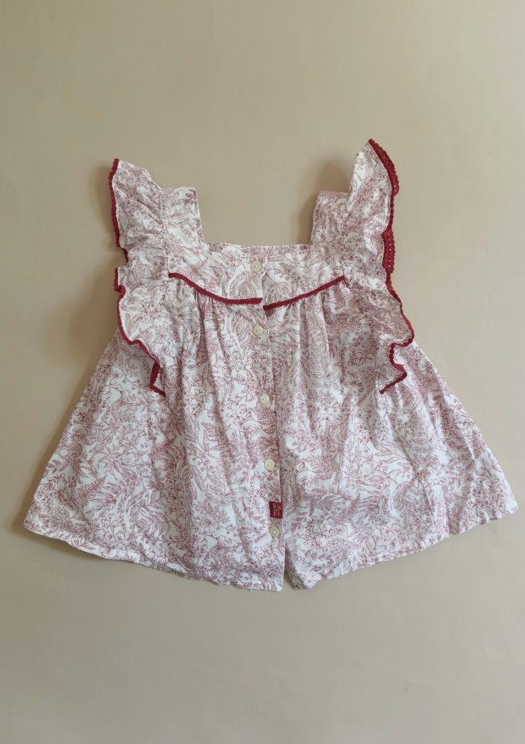 Tartine et Chocolat Blouse 3yo (Category: Babies & Kids Fashion) located in Cebu City. Submitted by little_mush.room (Listing ID 1468153516, Image 3). Description: - Brand: Tartine et Chocolat - Size: 100 /3yo - Color/Design: White with red botanical leaf print - Details: Ruffled shoulders with red scalloped trim, embroidered logo near the hem - Closure: Back button closure with branded mother-of-pearl buttons - Material: Soft, premium cotton .