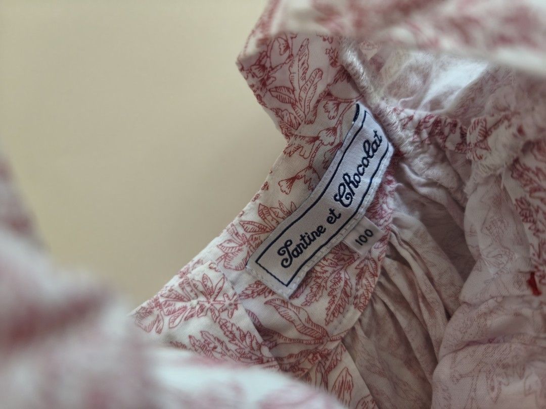 Tartine et Chocolat Blouse 3yo (Category: Babies & Kids Fashion) located in Cebu City. Submitted by little_mush.room (Listing ID 1468153516, Image 2). Description: - Brand: Tartine et Chocolat - Size: 100 /3yo - Color/Design: White with red botanical leaf print - Details: Ruffled shoulders with red scalloped trim, embroidered logo near the hem - Closure: Back button closure with branded mother-of-pearl buttons - Material: Soft, premium cotton .