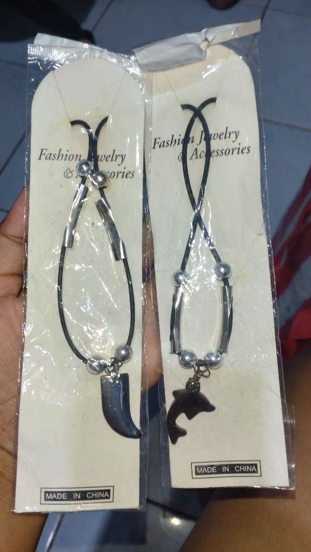 Tatoo and necklace set (Category: Bracelets) located in Valenzuela. Submitted by diane.35 (Listing ID 1468099322, Image 1). Description: - Set of 2 packaged fashion bracelets with black cords, silver-toned beads, and dolphin/claw charms - Includes 1 sheet of temporary tattoo transfer paper with geometric triangles, floral bouquets, and moon/star designs - All items brand new in original packaging with clear protective plastic wrap intact - Countr