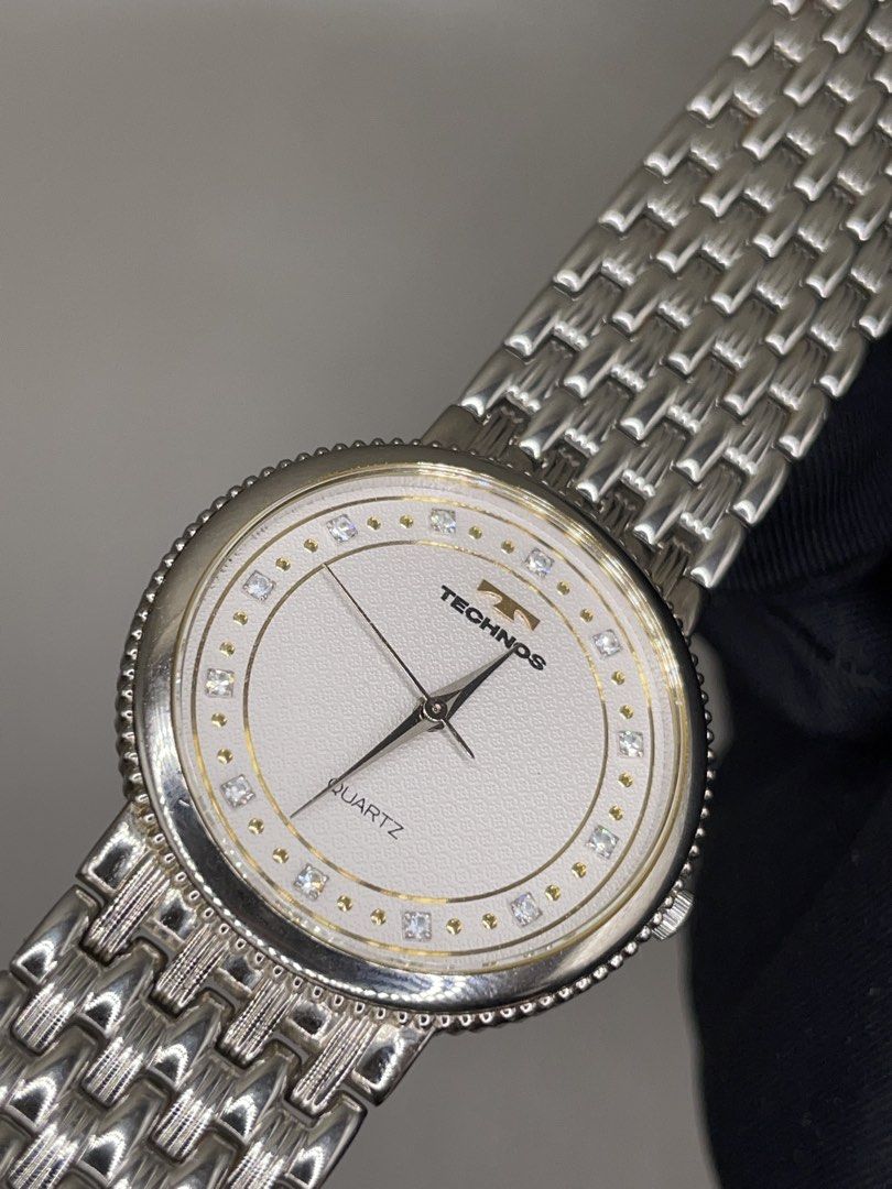 Technos Quartz Watch Swiss Made Silver Tone (Category: Men's Watches) located in Pateros City. Submitted by thevintagepatt_ (Listing ID 1468232773, Image 3). Description: Technos quartz watch with a textured white dial and crystal markers. Round silver case with a beaded bezel. Linked metal bracelet strap. Swiss M TE-063 stamped on the dial. Clean design, classic daily wear piece..