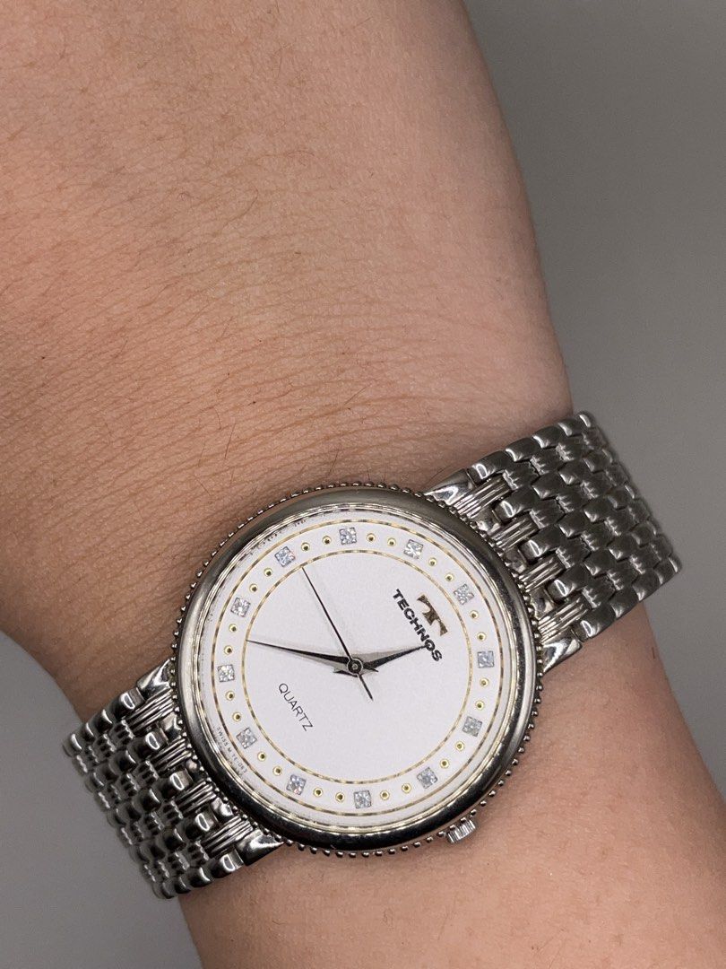 Technos Quartz Watch Swiss Made Silver Tone (Category: Men's Watches) located in Pateros City. Submitted by thevintagepatt_ (Listing ID 1468232773, Image 2). Description: Technos quartz watch with a textured white dial and crystal markers. Round silver case with a beaded bezel. Linked metal bracelet strap. Swiss M TE-063 stamped on the dial. Clean design, classic daily wear piece..