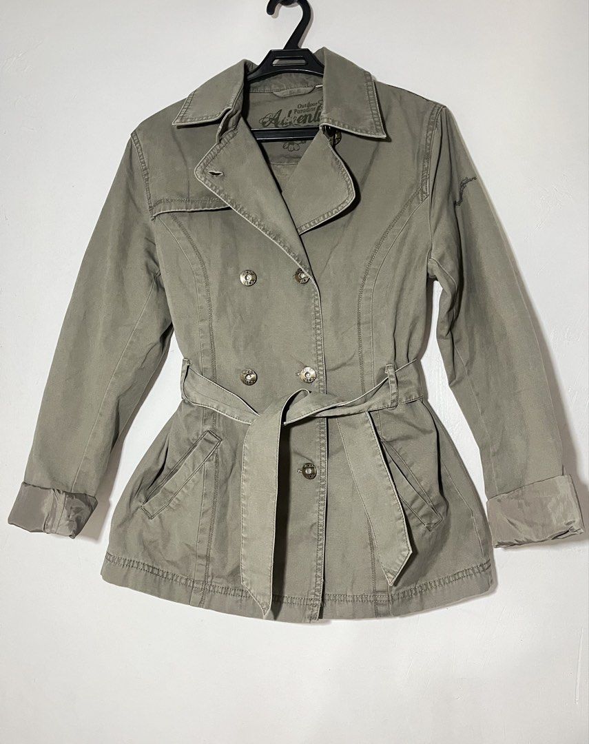 double-breasted belted trench jacket muted olive (Category: Coats, Jackets and Outerwear) located in Quezon City. Submitted by shopkeju (Listing ID 1468090744, Image 2). Description: Style: Short trench coat / trench jacket Color: Olive gray, khaki, or grayish sage green Closure: Double-breasted front with metallic buttons Collar: Wide notched lapel collar Waist: Matching adjustable tie belt Details: Fitted waist, structured seams, flap pockets, 