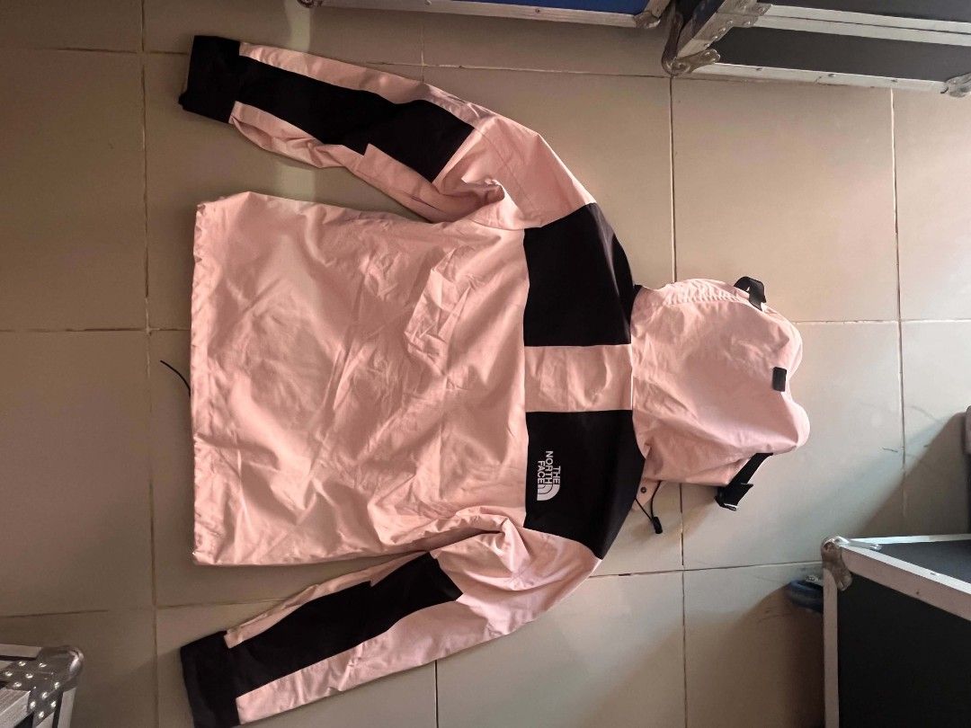 The North Face Pink Black Mountain Jacket (Category: Coats, Jackets and Outerwear) located in Manila. Submitted by necklie_tuballas (Listing ID 1468175373, Image 1). Description: - Brand: The North Face - Colorway: Pink and black with contrasting black cuffs and shoulder panels - Design: Hooded with adjustable drawstrings and snap button front closure - Details: Front chest pocket with bold brand logo printed on the chest - Versatility: Ideal cas