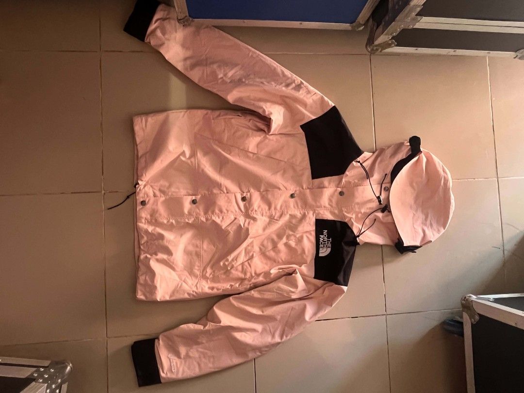 The North Face Pink Black Mountain Jacket (Category: Coats, Jackets and Outerwear) located in Manila. Submitted by necklie_tuballas (Listing ID 1468175373, Image 2). Description: - Brand: The North Face - Colorway: Pink and black with contrasting black cuffs and shoulder panels - Design: Hooded with adjustable drawstrings and snap button front closure - Details: Front chest pocket with bold brand logo printed on the chest - Versatility: Ideal cas