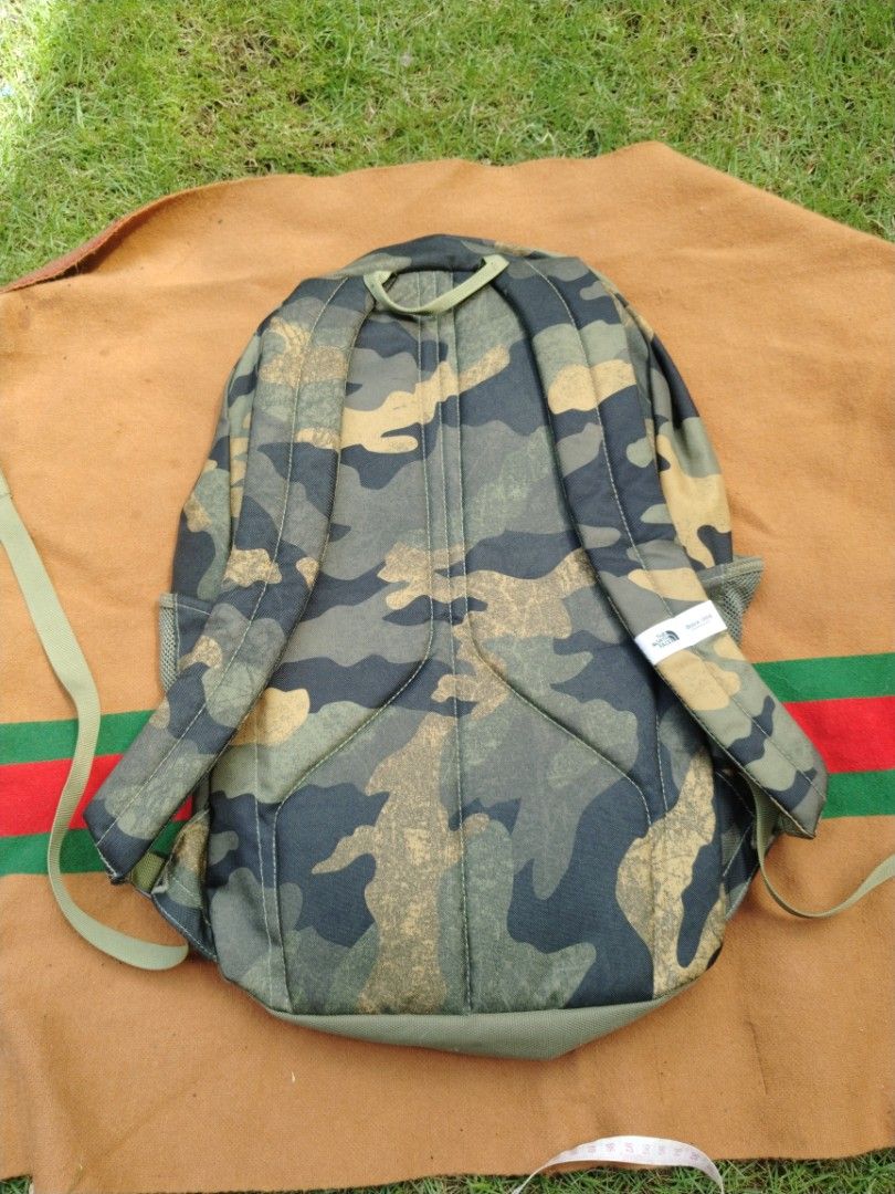 The North Face Rodey Camo Backpack (Category: Backpacks) located in Legazpi City. Submitted by genobecollectives (Listing ID 1468078711, Image 2). Description: - Brand: The North Face Rodey Backpack - Color: Green Camouflage Print - Condition: Clean inside and out, sturdy zippers - Storage: Spacious main compartment with internal sleeve, secondary zippered pocket, and mesh side water bottle pockets - Exterior: Front bungee cord system and embroid