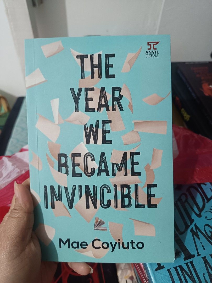 The Year We Became Invincible by Mae Coyiuto (Category: Storybooks) located in Taguig. Submitted by joeeey23 (Listing ID 1468193777, Image 1). Description: - Title: The Year We Became Invincible - Author: Mae Coyiuto - Publisher: Anvil Teens - Cover: Teal with scattered paper illustrations - Condition: Clean pages inside, minor storage spot on side edges - Genre: Great YA (Young Adult) contemporary read - SF/Shipping or Meet-ups available across 