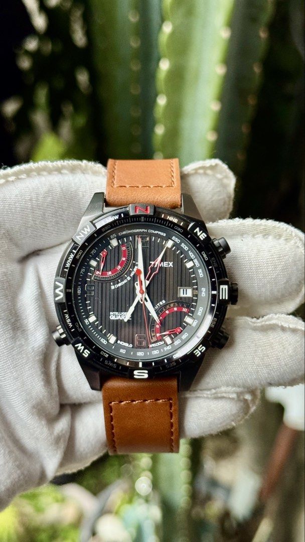 Timex Intelligent Quartz Chronograph Compass Watch (Category: Men's Watches) located in Manila. Submitted by junjun12356 (Listing ID 1468282486, Image 1). Description: - Brand: Timex Intelligent Quartz - Dial: Black textured with red/white accents, dual sub-dials, and date at 4 o'clock - Bezel: Compass bezel with cardinal directions - Case: Black ion-plated stainless steel - Strap: Tan leather strap with buckle closure - Movement: Multi-function 