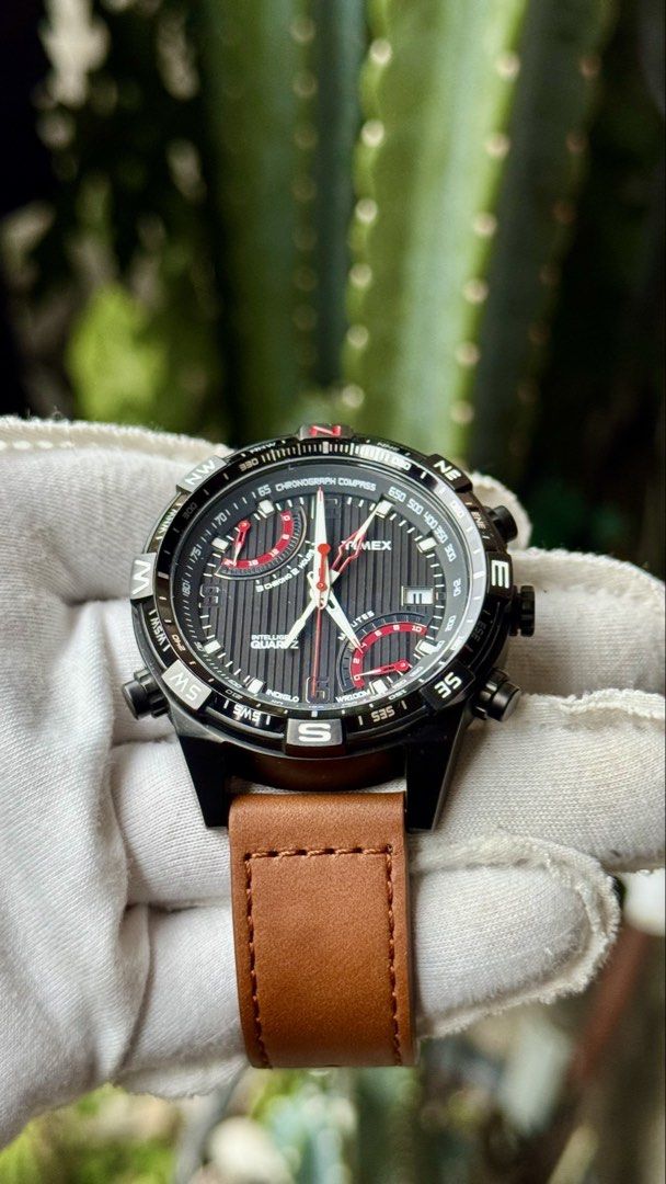 Timex Intelligent Quartz Chronograph Compass Watch (Category: Men's Watches) located in Manila. Submitted by junjun12356 (Listing ID 1468282486, Image 2). Description: - Brand: Timex Intelligent Quartz - Dial: Black textured with red/white accents, dual sub-dials, and date at 4 o'clock - Bezel: Compass bezel with cardinal directions - Case: Black ion-plated stainless steel - Strap: Tan leather strap with buckle closure - Movement: Multi-function 