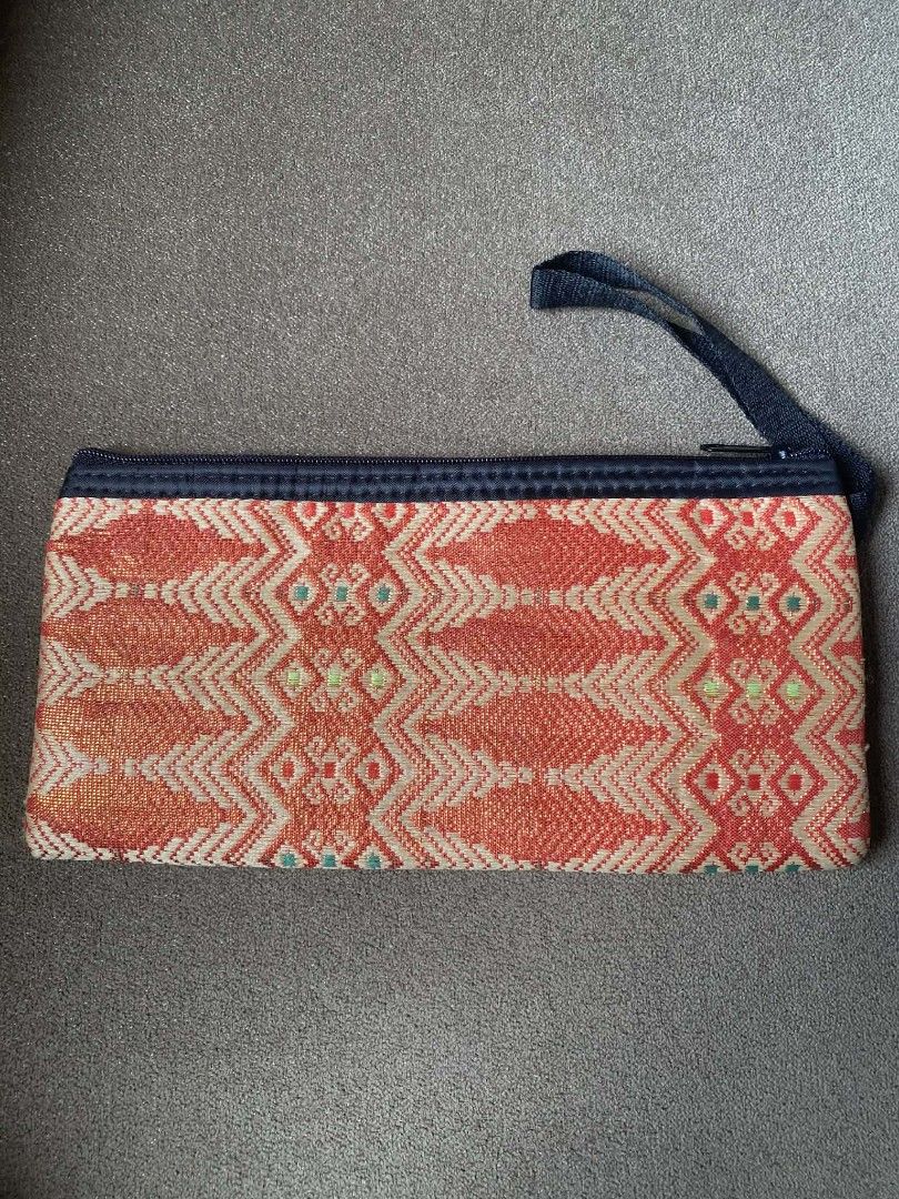 Traditional Woven Ethnic Pattern Zip Pouch with Wrist Strap (Category: Purses & Pouches) located in Zaragoza. Submitted by sherree1281 (Listing ID 1468059228, Image 1). Description: - Design: Traditional orange and beige woven pattern - Closure: Durable dark fabric zipper along the top - Portability: Includes a matching black wrist strap - Shape: Slim, rectangular, and lightweight - Usage: Ideal for cosmetics, phone, or everyday essentials.
