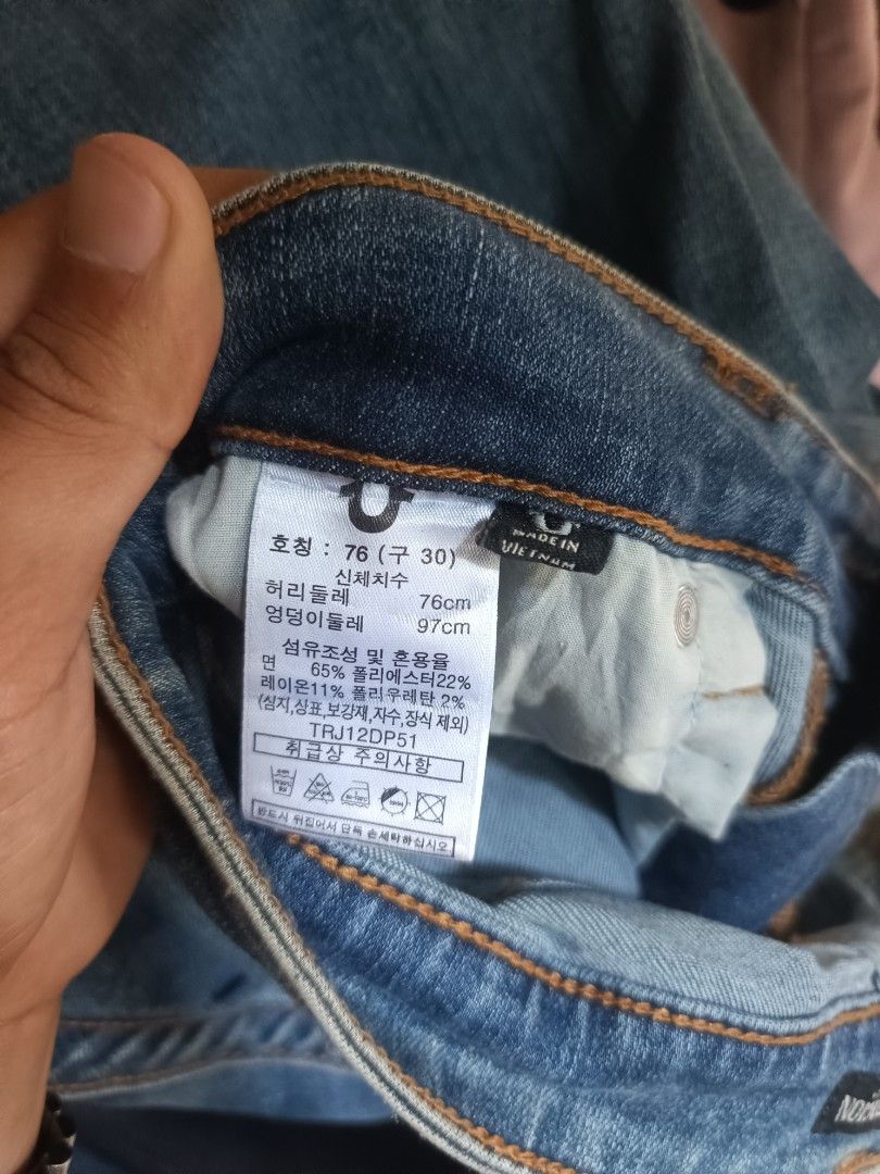 True Religion Jeans (Category: Jeans) located in Manila. Submitted by coyyimpothrift2 (Listing ID 1468219342, Image 2). Description: - Brand: True Religion - Color/Wash: Blue denim, clean wash - Size: 30 (Korean tag 76) - Features: Classic pocket flaps with signature colorful stitching, button closure - Material: Polyester, rayon, and polyurethane blend - Origin: Made in Vietnam - Condition: Clean and ready to wear.