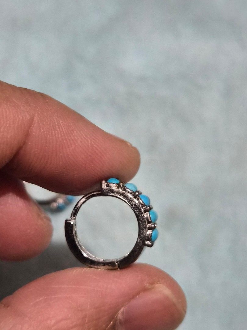 Turquoise Hoop Earrings with Silver Lattice Pattern (Category: Earrings) located in Mandaue City. Submitted by chuchi152615 (Listing ID 1468069821, Image 3). Description: - Style: Turquoise stone hoop earrings in silver-tone metal - Design: Double row of round blue stones with a detailed crisscross lattice cutout on the sides and back - Closure: Secure hinged clasp - Condition: Brand new, unworn, still attached to the original paper backing card 
