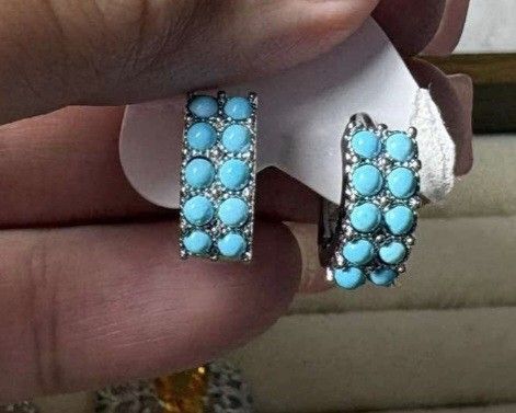 Turquoise Hoop Earrings with Silver Lattice Pattern (Category: Earrings) located in Mandaue City. Submitted by chuchi152615 (Listing ID 1468069821, Image 1). Description: - Style: Turquoise stone hoop earrings in silver-tone metal - Design: Double row of round blue stones with a detailed crisscross lattice cutout on the sides and back - Closure: Secure hinged clasp - Condition: Brand new, unworn, still attached to the original paper backing card 
