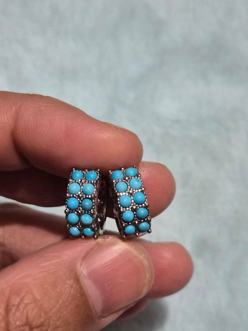 Turquoise Hoop Earrings with Silver Lattice Pattern (Category: Earrings) located in Mandaue City. Submitted by chuchi152615 (Listing ID 1468069821, Image 2). Description: - Style: Turquoise stone hoop earrings in silver-tone metal - Design: Double row of round blue stones with a detailed crisscross lattice cutout on the sides and back - Closure: Secure hinged clasp - Condition: Brand new, unworn, still attached to the original paper backing card 