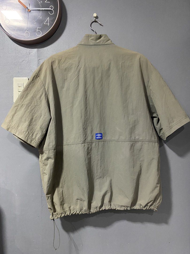Umbro Short Sleeve Quarter Zip Windbreaker (Category: Coats, Jackets and Outerwear) located in Tanay. Submitted by judevalcorza (Listing ID 1468224978, Image 2). Description: - Brand/Model: Umbro Sage Green Short Sleeve Windbreaker - Size: Xlarge Length 29 Width 26 - Details: Quarter-zip with branded pull tab, large front kangaroo pocket - Branding: Embroidered chest logo and blue woven patch on the back - Fit: Adjustable bungee cord hem - Materi
