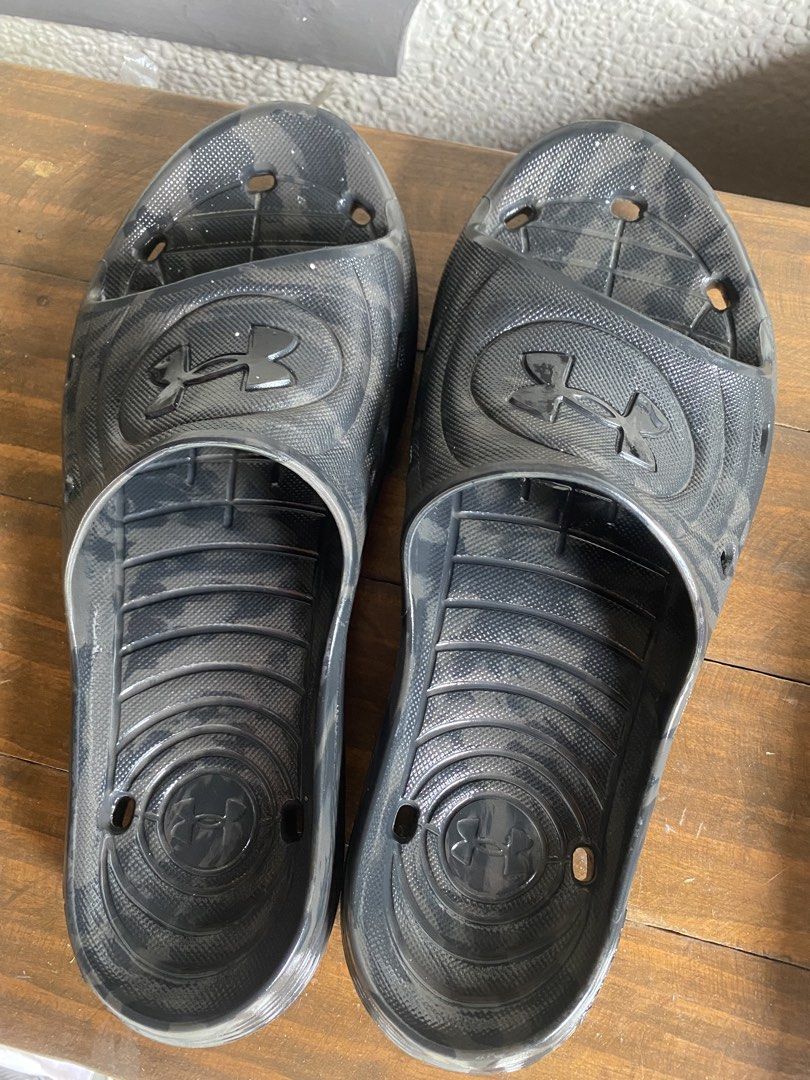 Under Armour Black Camo Slides Sandals (Category: Slippers & Slides) located in Manila. Submitted by pems25 (Listing ID 1468283002, Image 3). Description: - Size 10 (Male) - Brand: Under Armour - Color/Design: Dark grey and black camouflage print - Features: Molded footbed, textured grip, and drainage ventilation holes - Branding: Raised Under Armour logo on the strap - Best For: Pool, beach, casual wear, or post-workout recovery - Condition: Bra