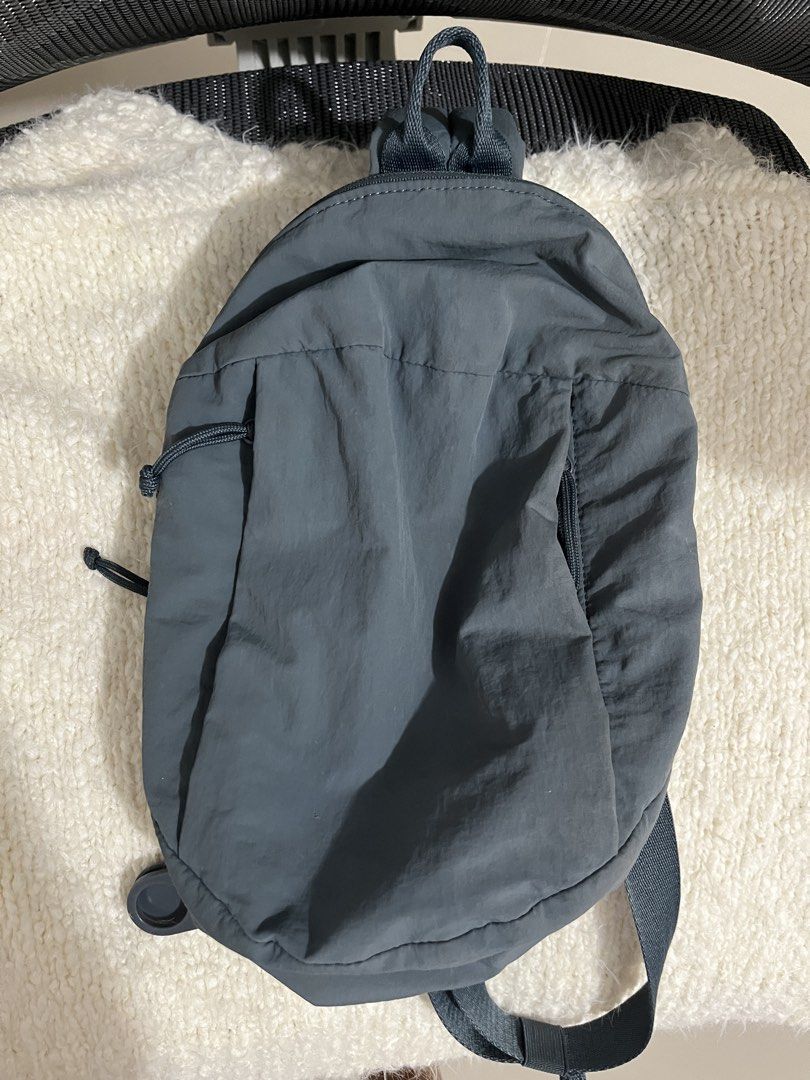 Uniqlo Round Mini Sling Bag Nylon (Category: Cross-body Bags) located in Muntinlupa City. Submitted by little.declutter (Listing ID 1468090267, Image 1). Description: - Brand: Uniqlo - Material: Durable nylon - Compartments: Zippered main compartment and front pocket - Interior Features: Slip pocket and handy key ring strap - Strap: Adjustable crossbody strap - Condition/Details: Clean interior lining with brand and care tags attached.