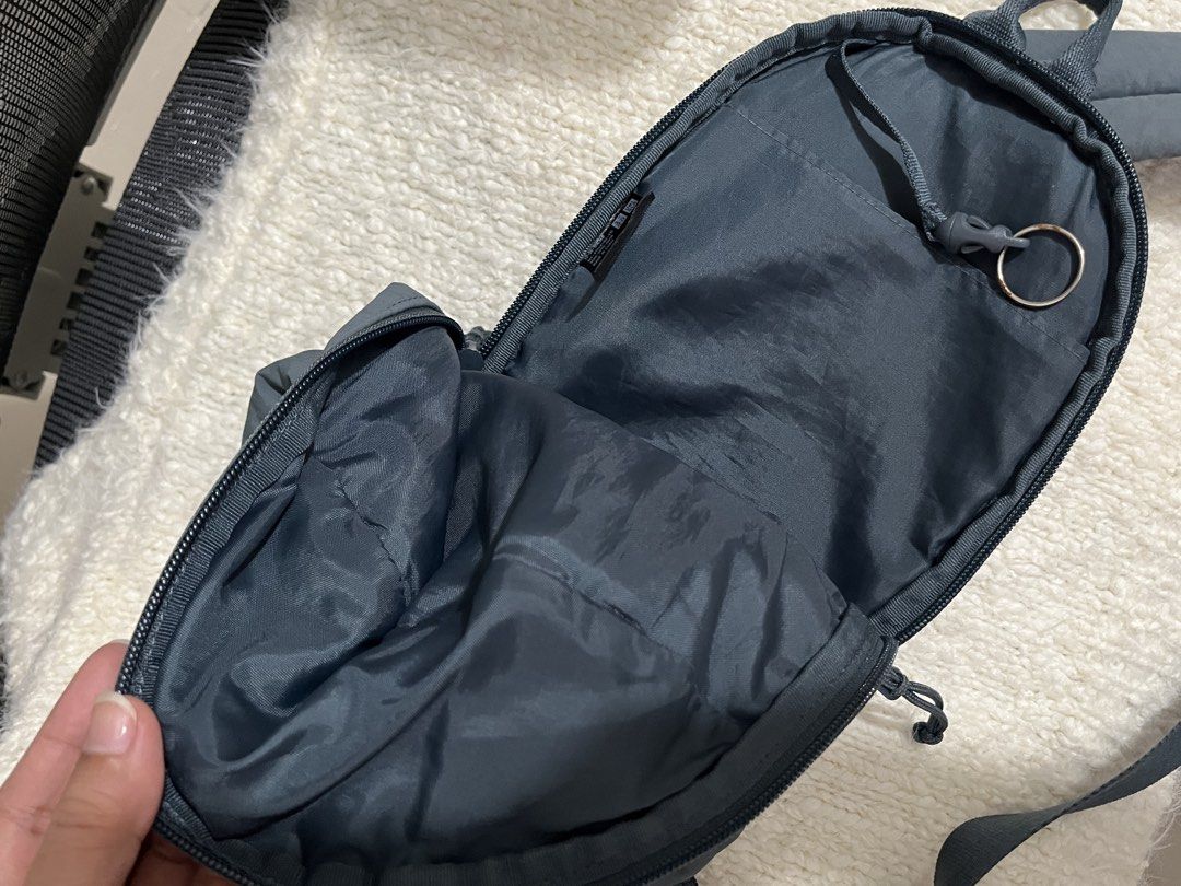 Uniqlo Round Mini Sling Bag Nylon (Category: Cross-body Bags) located in Muntinlupa City. Submitted by little.declutter (Listing ID 1468090267, Image 3). Description: - Brand: Uniqlo - Material: Durable nylon - Compartments: Zippered main compartment and front pocket - Interior Features: Slip pocket and handy key ring strap - Strap: Adjustable crossbody strap - Condition/Details: Clean interior lining with brand and care tags attached.
