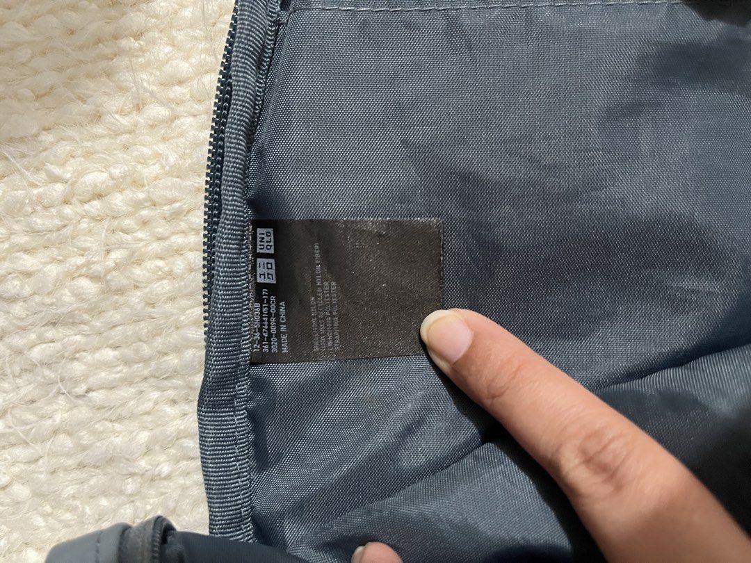 Uniqlo Round Mini Sling Bag Nylon (Category: Cross-body Bags) located in Muntinlupa City. Submitted by little.declutter (Listing ID 1468090267, Image 2). Description: - Brand: Uniqlo - Material: Durable nylon - Compartments: Zippered main compartment and front pocket - Interior Features: Slip pocket and handy key ring strap - Strap: Adjustable crossbody strap - Condition/Details: Clean interior lining with brand and care tags attached.