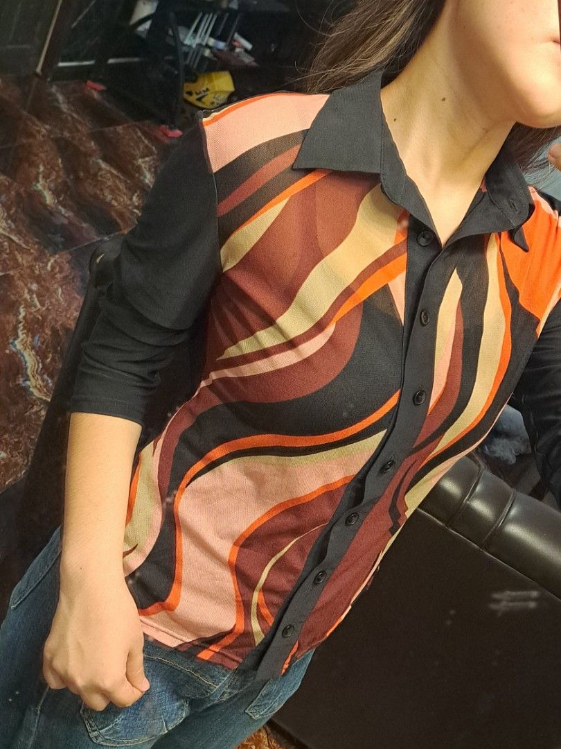 Unit One Abstract Wave Red Button-Down Blouse Y2K/Vintage (Category: Blouses) located in Iligan City. Submitted by xania_danielle03 (Listing ID 1468075813, Image 2). Description: - Brand: Unit One - Size: S (tag on collar) - Design: Colorful abstract wave pattern (orange, maroon, pink, cream) on front - Details: Solid black collar, placket, and sleeves with button-up closure - Material: Lightweight, sheer fabric.