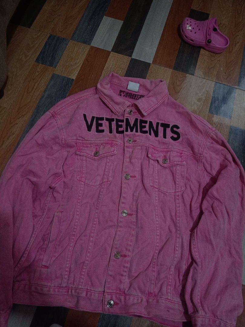 VETEMENTS Pink Denim Jacket Size L (Category: Coats, Jackets and Outerwear) located in Baguio. Submitted by solo_ukay (Listing ID 1468257137, Image 1). Description: - Brand/Model: VETEMENTS pink denim jacket - Size: L - Material: 100% cotton, Made in China - Design Details: Bold black lettering on chest, large energy label graphic patch on back, and brown leather patch near bottom hem - Features: Full button-up front with metal hardware and multi
