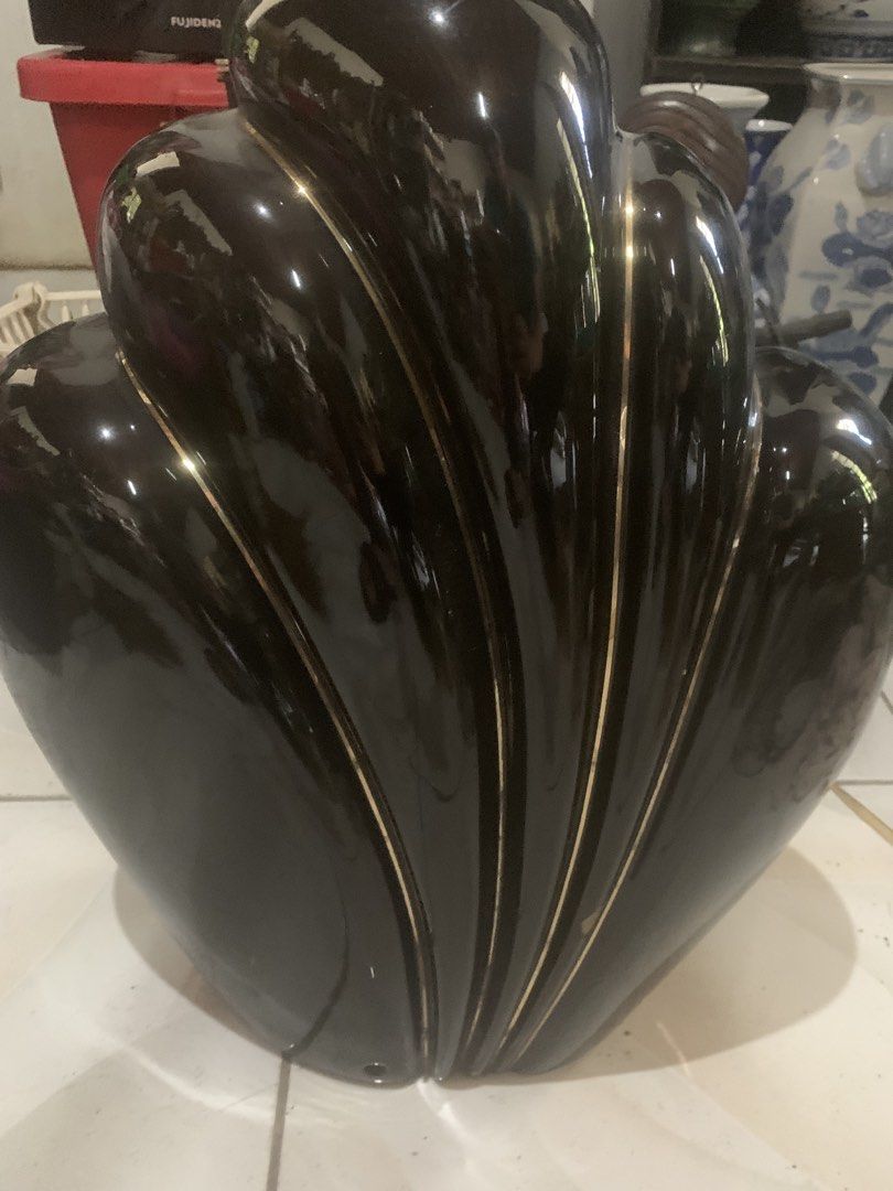 Vintage Black Ceramic Art Deco Lamp Base (Category: Lighting) located in Quezon City. Submitted by sojisup (Listing ID 1468142238, Image 2). Description: - Style: Vintage Art Deco black ceramic lamp base with elegant curved shell design - Details: Glossy finish with striking gold trim lines along the ridges - Build: Heavy and stable base featuring a metal harp fixture and threaded rod - Condition: Good vintage condition with some oxidation on met
