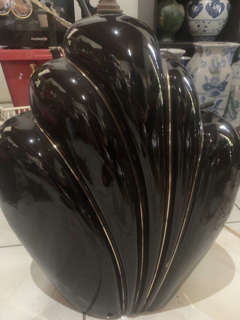 Vintage Black Ceramic Art Deco Lamp Base (Category: Lighting) located in Quezon City. Submitted by sojisup (Listing ID 1468142238, Image 3). Description: - Style: Vintage Art Deco black ceramic lamp base with elegant curved shell design - Details: Glossy finish with striking gold trim lines along the ridges - Build: Heavy and stable base featuring a metal harp fixture and threaded rod - Condition: Good vintage condition with some oxidation on met