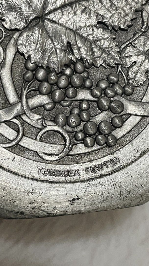 Vintage round pewter hip flask (Category: Vintage Collectibles) located in Quezon City. Submitted by sissymissy1527 (Listing ID 1468129637, Image 3). Description: Featuring a raised grape vine and leaf medallion What u see is what u get Selling as is where is Key Details: • Material: 97% pewter alloy (stamped with brand and composition details on the piece). • Design: Circular pocket/hip flask with a textured screw cap and an embossed grape clust
