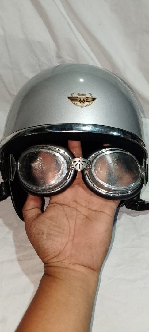 Vintage Silver Motorcycle Helmet With Goggles (Category: Bicycles) located in Quezon City. Submitted by jpnvintageonline (Listing ID 1468236639, Image 2). Description: - Style: Classic retro half-face design with glossy silver finish - Extras: Includes attached silver-framed riding goggles with dark padding - Branding: Features a stylish gold and black 'Vintage' wing emblem on the front - Comfort & Fit: Comfortable black interior lining and secur