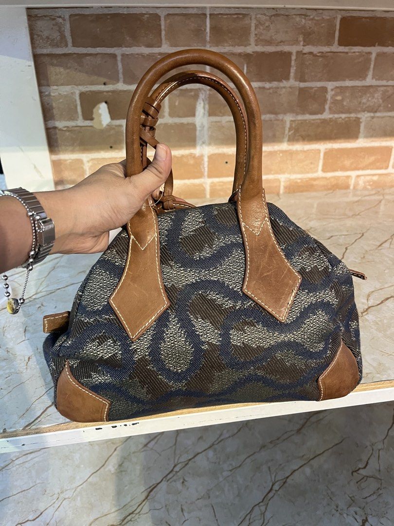 Vivienne Westwood (Category: Luxury Bags & Wallets) located in Manila. Submitted by hello_juicyyyy (Listing ID 1468279560, Image 2). Description: Vintage Vivienne Westwood Bag Fabric/Leather Approx dimensions: 21x28x12cm Good condition, hardly worn Bag shows some light wear throughout, mainly to lining, hardware, brown leather (scratches) and the bottom of the bag Please refer to all photos for the exact condition.