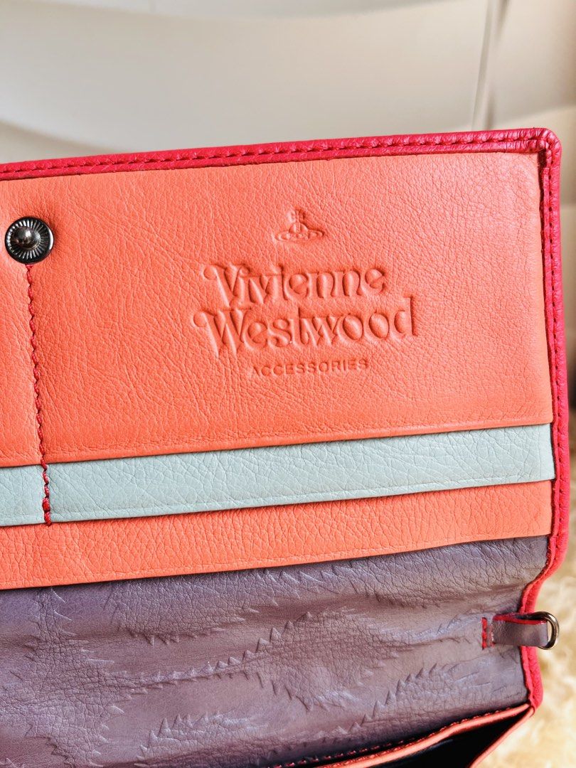 Vivienne Westwood Leather Wallet (Category: Wallets & Card holders) located in Davao. Submitted by goodthingsph_ (Listing ID 1468076019, Image 2). Description: -(Made in Italy) - Exterior: Signature metal orb emblem on the front flap - Interior: Colorful multi-tone lining featuring orange, light blue, and patterned fabric - Functionality: Multiple card slots and compartments for everyday organization - Condition: Excellent.